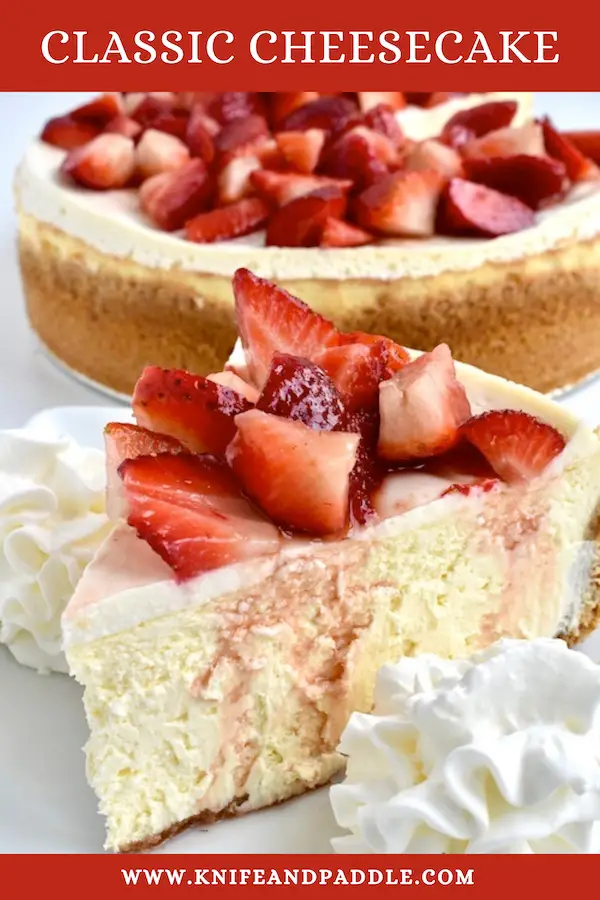 Slice of cheesecake topped with fresh strawberries and whipped cream