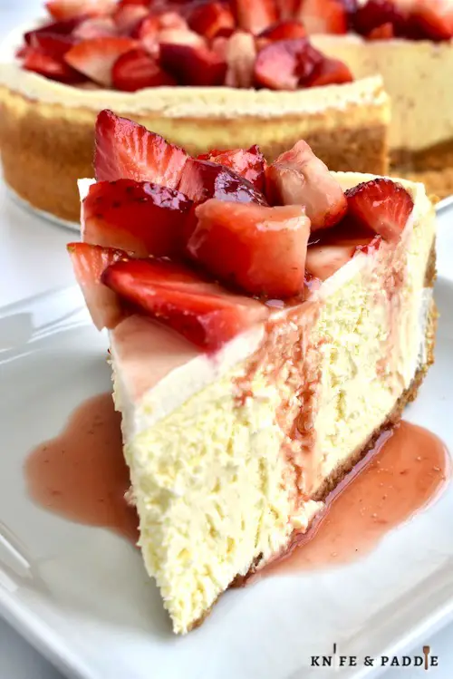 Slice of cheesecake topped with fresh strawberries