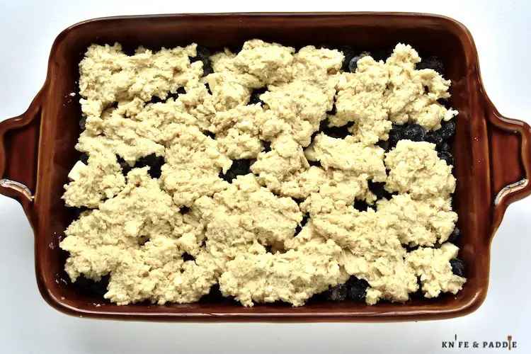 Cobbler topping on blueberry mixture in a baking dish