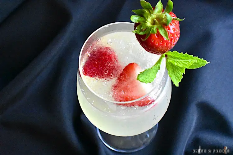 Lillet Spritz with crushed ice and strawberries and mint sprig for garnish