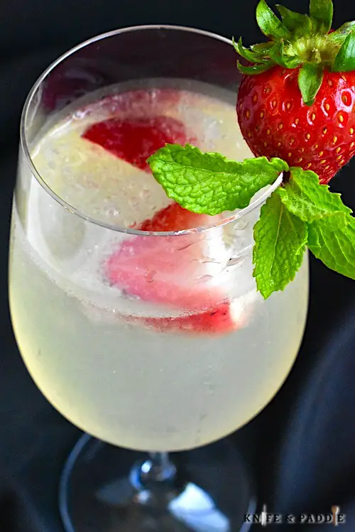 Lillet Spritz with crushed ice and strawberries and mint sprig for garnish