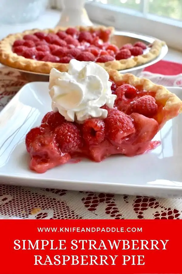 Slice of Simple Strawberry Raspberry Pie on a plate topped with whipped cream