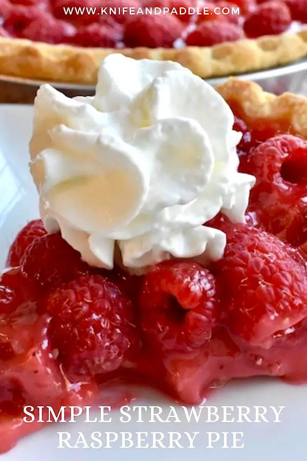 Slice of Simple Strawberry Raspberry Pie on a plate topped with whipped cream