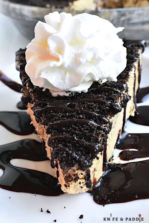 Creamy Peanut Butter Pie with crushed Oreos topped with chocolate drizzle and whipped cream