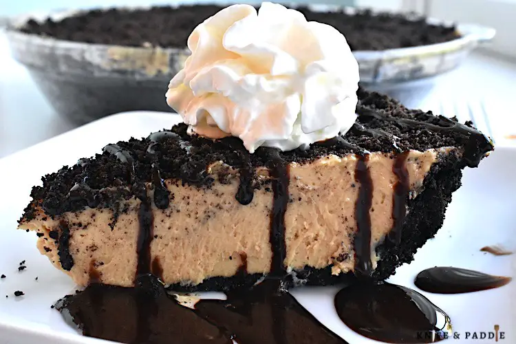 Creamy Peanut Butter Pie with crushed Oreos topped with chocolate drizzle and whipped cream