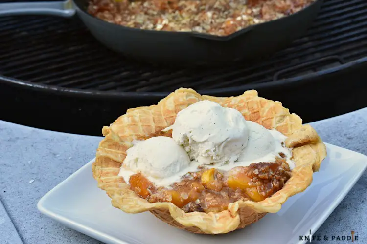 Grilled Peach Crisp Sundaes in a waffle bowl topped with vanilla ice cream 