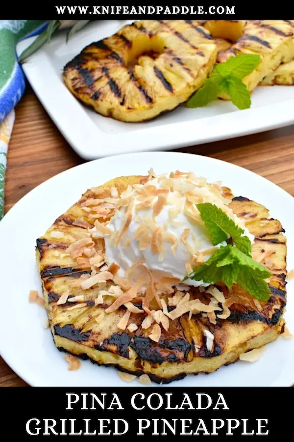 Piña Colada Grilled Pineapple on a plate with coconut whipped topping and toasted shredded coconut 