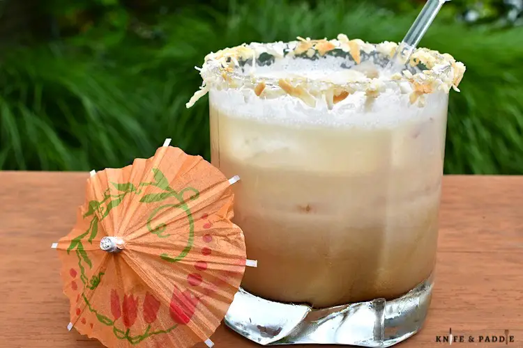 Coconut White Russian in a rocks glass filled with ice and rimmed with toasted coconut 