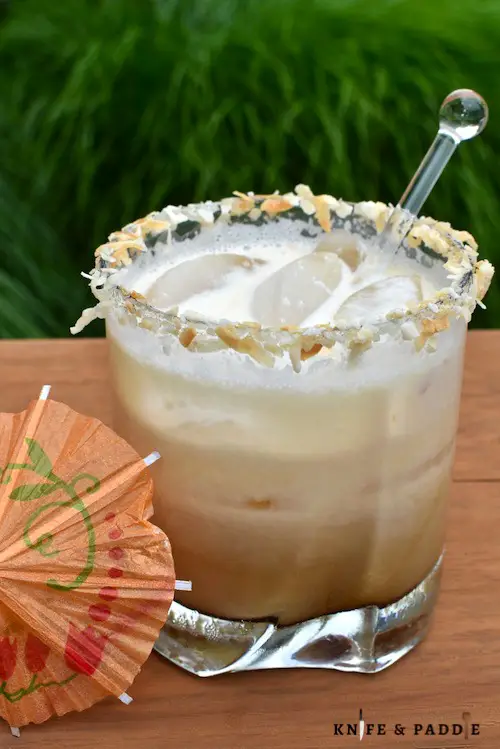 Coconut White Russian in a rocks glass filled with ice and rimmed with toasted coconut 