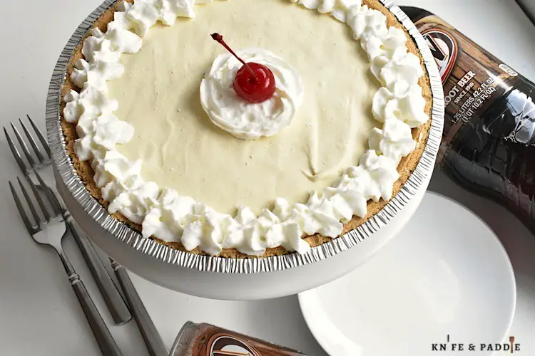 Root Beer Float Pie topped with whipped cream and a maraschino cherry