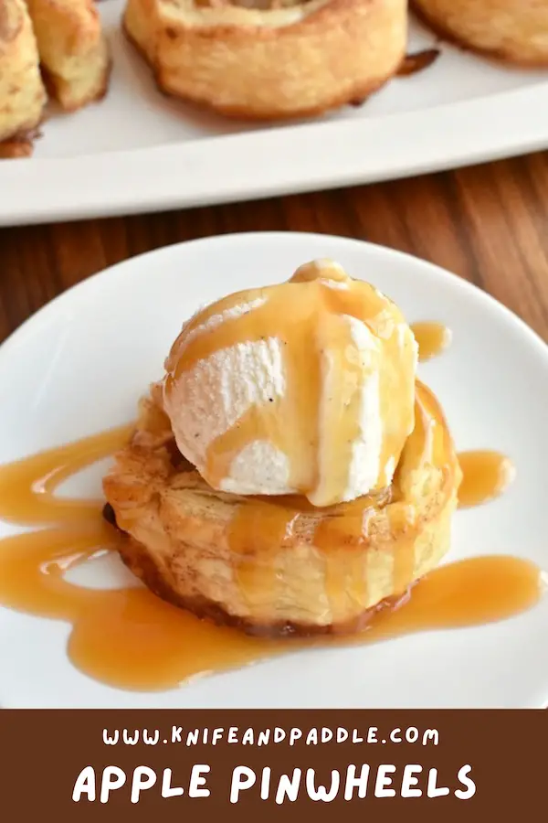 Apple Pinwheels topped with vanilla ice cream and caramel sauce on a plate