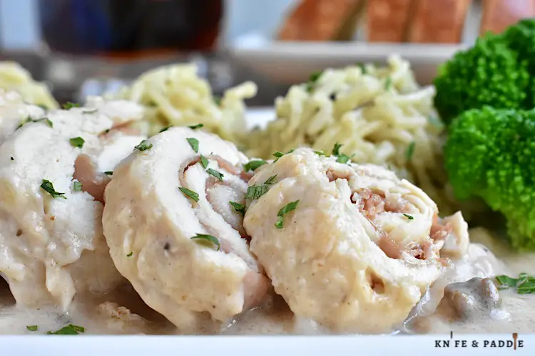 Crockpot Chicken Saltimbocca served on a plate topped with fresh parsley and accompanied by rice and broccoli