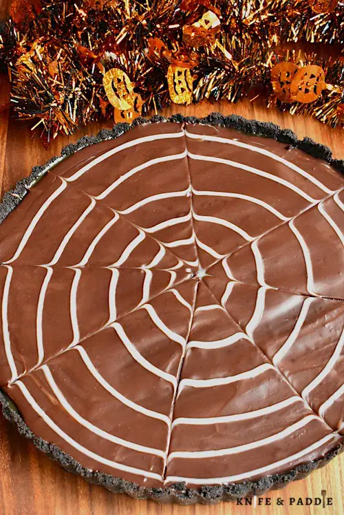 Halloween No-Bake Salted Caramel Tart with an Oreo crust and a white chocolate spider web ganache