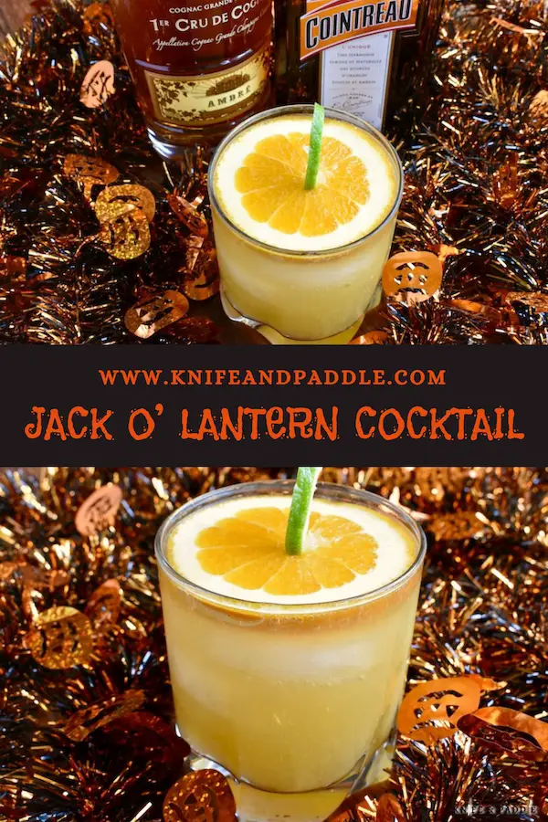 Jack O' Lantern Cocktail made with cognac, cointreau, orange juice and ginger ale mixed together to create a festive Halloween cocktail garnished with a pumpkin made from a slice of orange and a lime peel