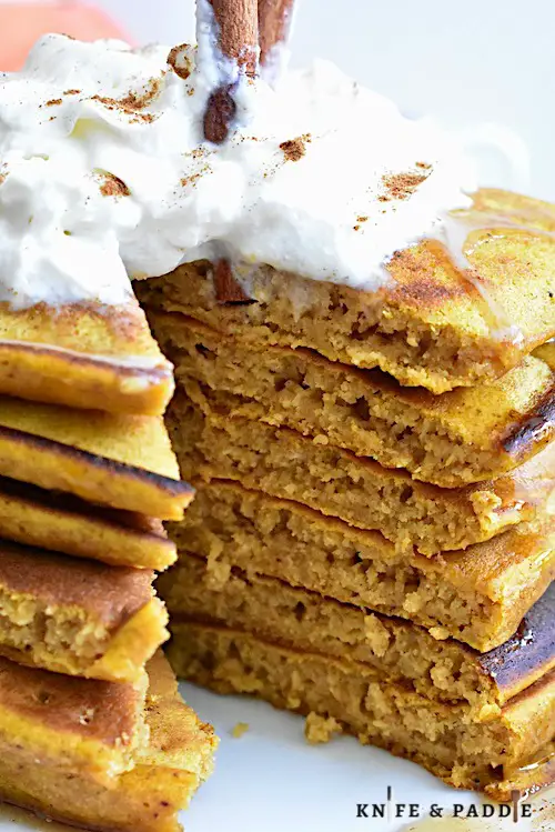 Pumpkin Pancakes with maple syrup topped with whipped cream