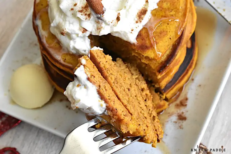 Pumpkin Pancakes with maple syrup topped with whipped cream