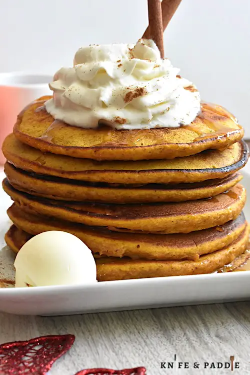 Pumpkin Pancakes with maple syrup topped with whipped cream