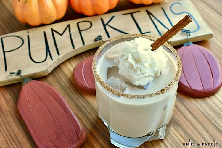 Pumpkin Spice White Russian with spiced rim and topped with whipped cream and a cinnamon stick