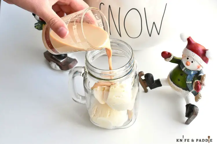 Baileys poured over two scoops of ice cream in a mug