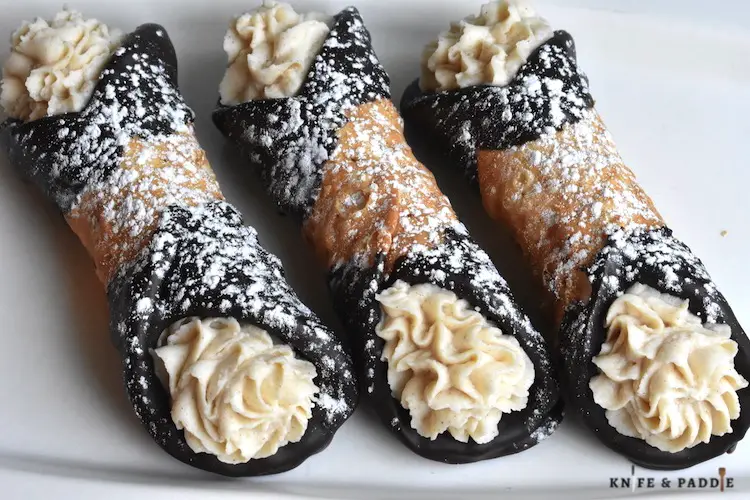 Chocolate Covered Cannoli sprinkled with powdered sugar