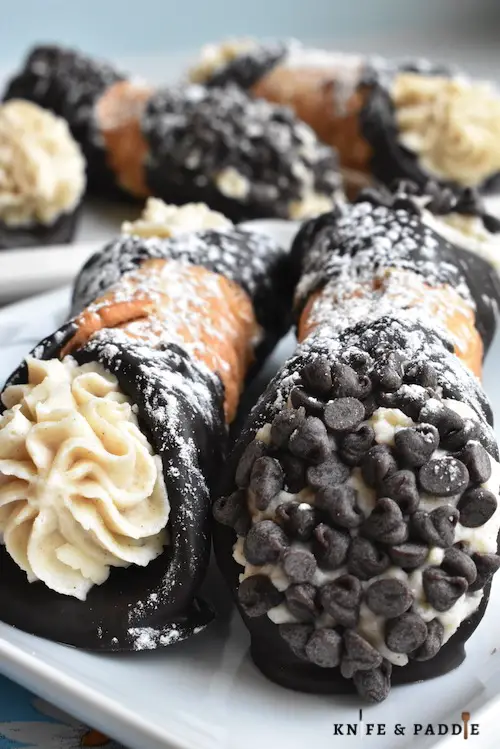 Chocolate Covered Cannoli sprinkled with powdered sugar