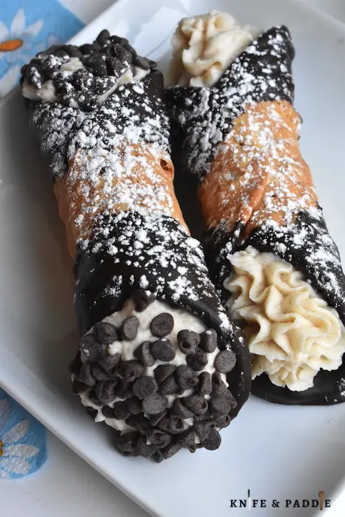 Chocolate Covered Cannoli sprinkled with powdered sugar